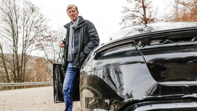 Walter Röhrl an der Tür des Porsche Taycan